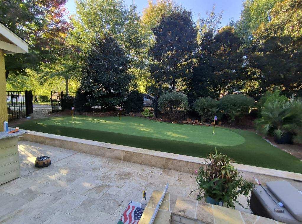 Backyard Tour Greens putting green with travertine patio